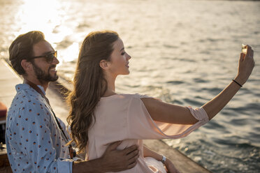 Romantisches Paar macht Smartphone-Selfie auf einem Boot im Jachthafen von Dubai, Vereinigte Arabische Emirate - CUF17236