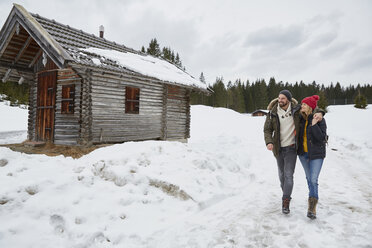 Couple hiking from log cabin in winter, Elmau, Bavaria, Germany - CUF17250