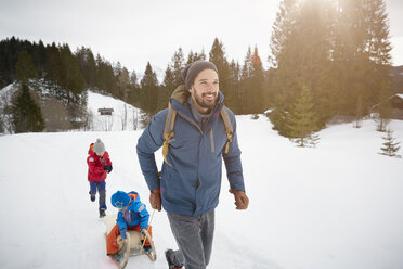 Junger Mann zieht Söhne auf Schlitten in verschneiter Landschaft, Elmau, Bayern, Deutschland - CUF17252