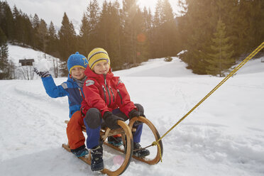 Junge und Bruder werden auf einem Schlitten im Schnee gezogen, Elmau, Bayern, Deutschland - CUF17260