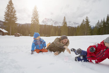 Junger Mann und Söhne bei einer Schneeballschlacht im Winter, Elmau, Bayern, Deutschland - CUF17262