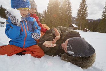 Vater und Söhne bei einer Schneeballschlacht im Winter, Elmau, Bayern, Deutschland - CUF17265