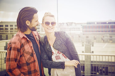 Portrait of cool mid adult couple on rooftop parking lot - CUF17272