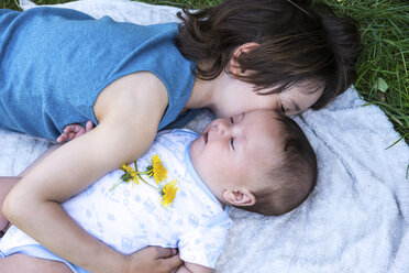 Boy hugging baby brother in garden - CUF17288