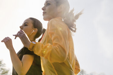 Two female friends exercising outdoors, running - CUF17349