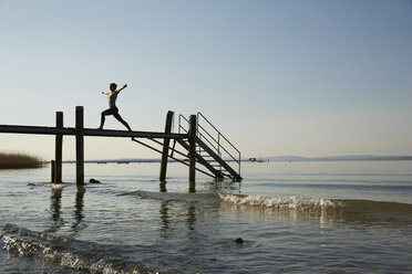 Silhouette der Frau auf dem Pier Arme offen, Beine auseinander in Yoga-Position - CUF17367