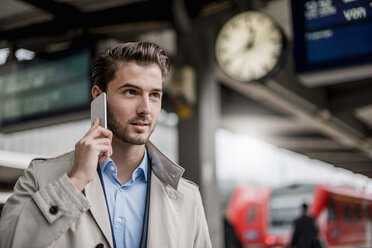 Businessman at the station on cell phone - DIGF04544