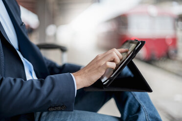 Nahaufnahme eines Geschäftsmannes am Bahnhof, der ein Tablet benutzt - DIGF04551