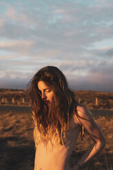 Island, nackte junge Frau bei Sonnenuntergang - KKAF01109