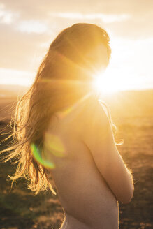 Island, nackte junge Frau bei Sonnenuntergang - KKAF01111