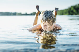 Junge in einem See, der ins Wasser bläst - MJF02262