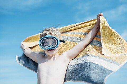 Junge mit Taucherbrille und Strandtuch im Freien, lizenzfreies Stockfoto