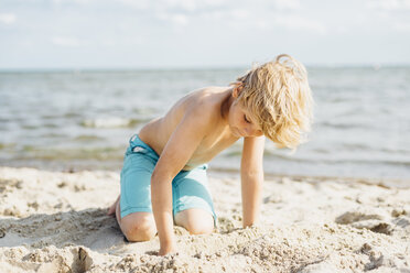 Blonder Junge spielt mit Sand am Strand - MJF02295