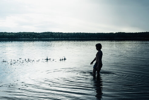 Junge in einem See in der Abenddämmerung - MJF02306