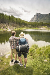 Rear view of father and son looking at view of mountain over Greenough lake, Red Lodge, Montana, USA - ISF06412