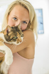 Frau kuschelt mit Katze und schaut in die Kamera - ISF06515