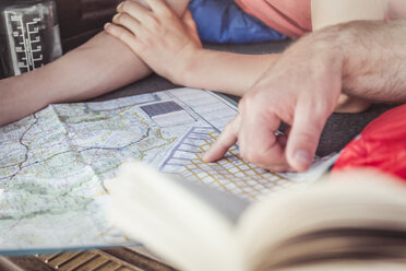 Close up man and teenage son hands pointing at map whilst lying in vehicle - CUF17414