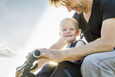 Father and baby daughter riding bike together - CUF17469