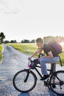 Vater und kleine Tochter fahren zusammen Fahrrad - CUF17470