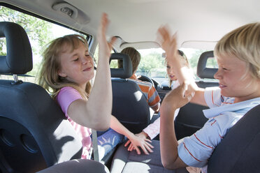 Streitende Kinder auf dem Rücksitz eines Fahrzeugs während einer Autofahrt - CUF17489