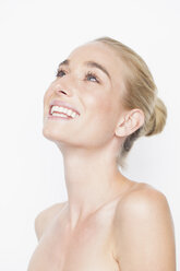 Woman with bare shoulders and hair slicked back looking up smiling - CUF17637