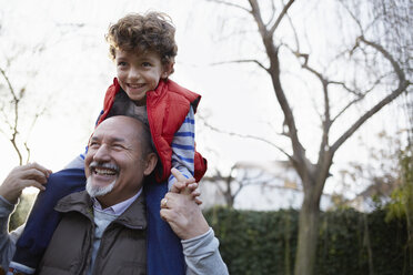 Mature man carrying grandson on shoulders smiling - CUF17659