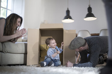 Parents playing with baby boy and cardboard box - CUF17662