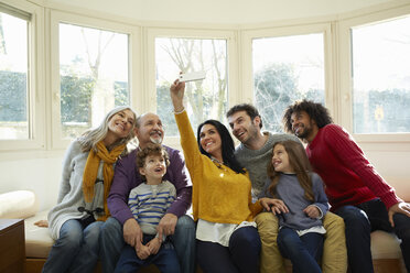 Mehrgenerationenfamilie auf dem Fensterplatz mit Smartphone für ein Selfie - CUF17684