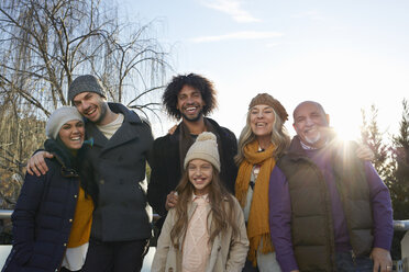 Mehrgenerationenfamilie mit Mänteln und Strickmützen, die lächelnd ihre Familie betrachtet - CUF17694
