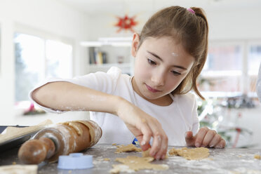 Girl looking down rolling out dough cookie dough - CUF17710