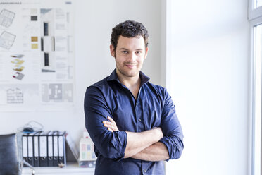 Mid adult man in office arms folded looking at camera smiling - CUF17739