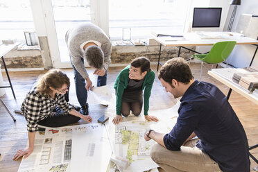 Hochformatige Ansicht von Architekten im Büro, die einen Bauplan besprechen - CUF17743