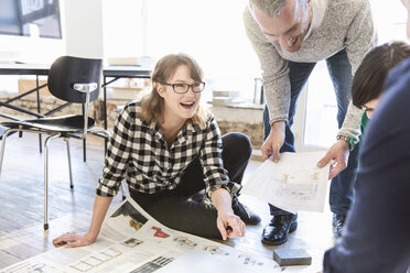 Architekten in einem Büro besprechen lächelnd einen Bauplan - CUF17744