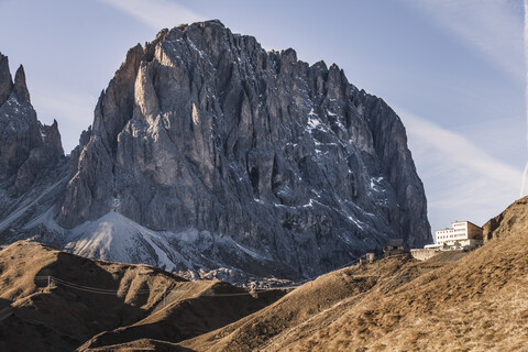 Zerklüftete Berglandschaft und Gebäude am Hang, Dolomiten, Italien, lizenzfreies Stockfoto