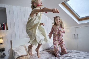 Mädchen springen auf dem Bett im Dachgeschoss - CUF17896
