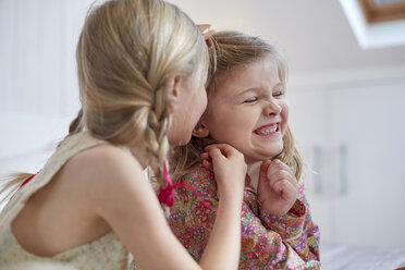 Girls sharing secret in loft room - CUF17897