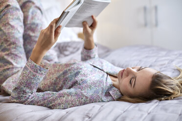 Frau im Pyjama liest Buch im Bett - CUF17908