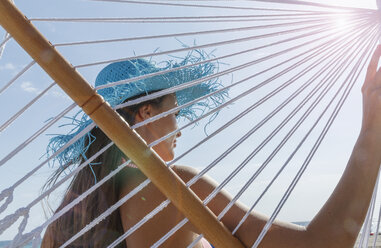 Rear view of young woman on hammock at Miami beach, Florida, USA - ISF06667