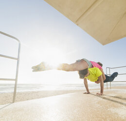 Paar übt Partner-Yoga auf dem Rettungsschwimmerturm am Strand - ISF06714