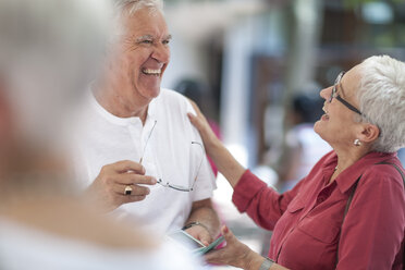 Senior man and mature woman chatting and laughing in city - ISF06746