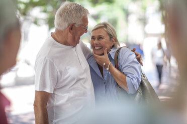 Senior man and woman laughing together in city - ISF06747