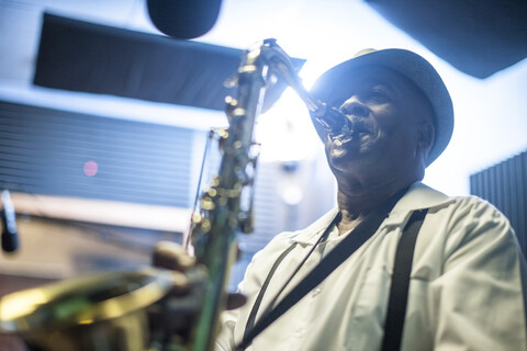 Männlicher Musiker im Aufnahmestudio, der Saxophon spielt, lizenzfreies Stockfoto