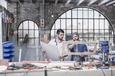 Craftsmen inspecting frame in antique restoration workshop - ISF06771