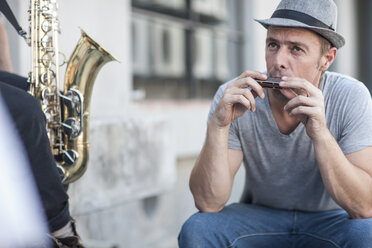 Street musician playing harmonica - ISF06792