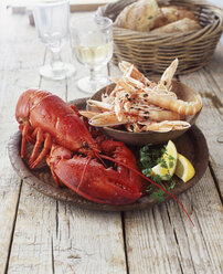 Plate of lobster and prawns with wicker basket of bread - CUF18021