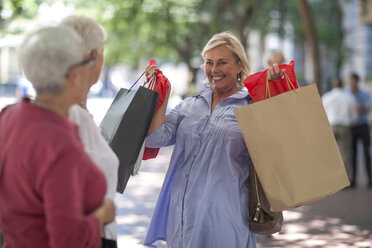 Ältere und reife Frauen halten Einkaufstüten in der Stadt hoch - ISF06802