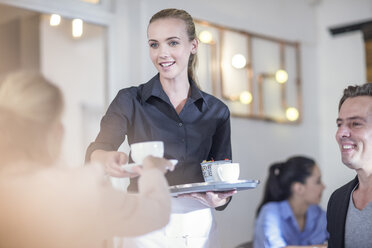 Waitress serving coffee to customers in restaurant - ISF06808