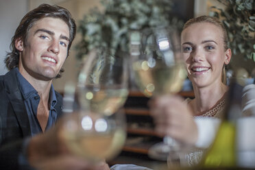 Couple toasting with friend in restaurant - ISF06819