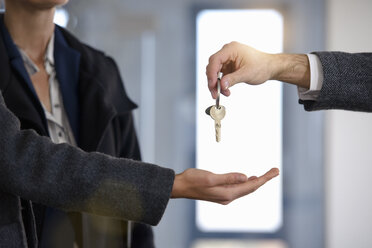 Cropped shot of man handing new office keys to businesswomen - CUF18110