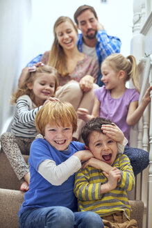 Glückliche Eltern und Kinder auf der Treppe sitzend - CUF18210